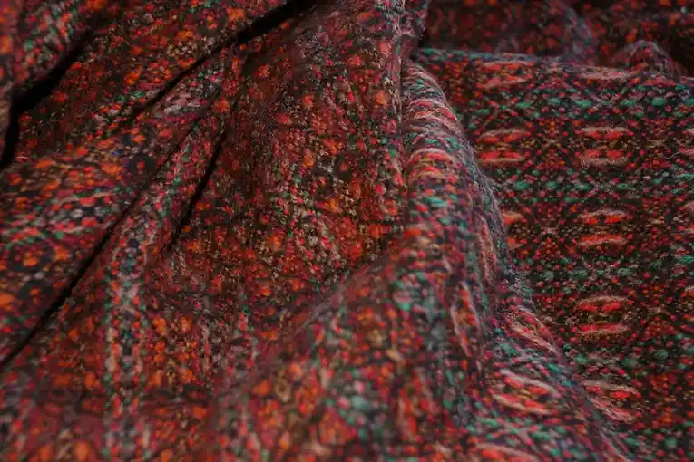 Close view of a hand-woven cloth in deep red with a small repeating pattern